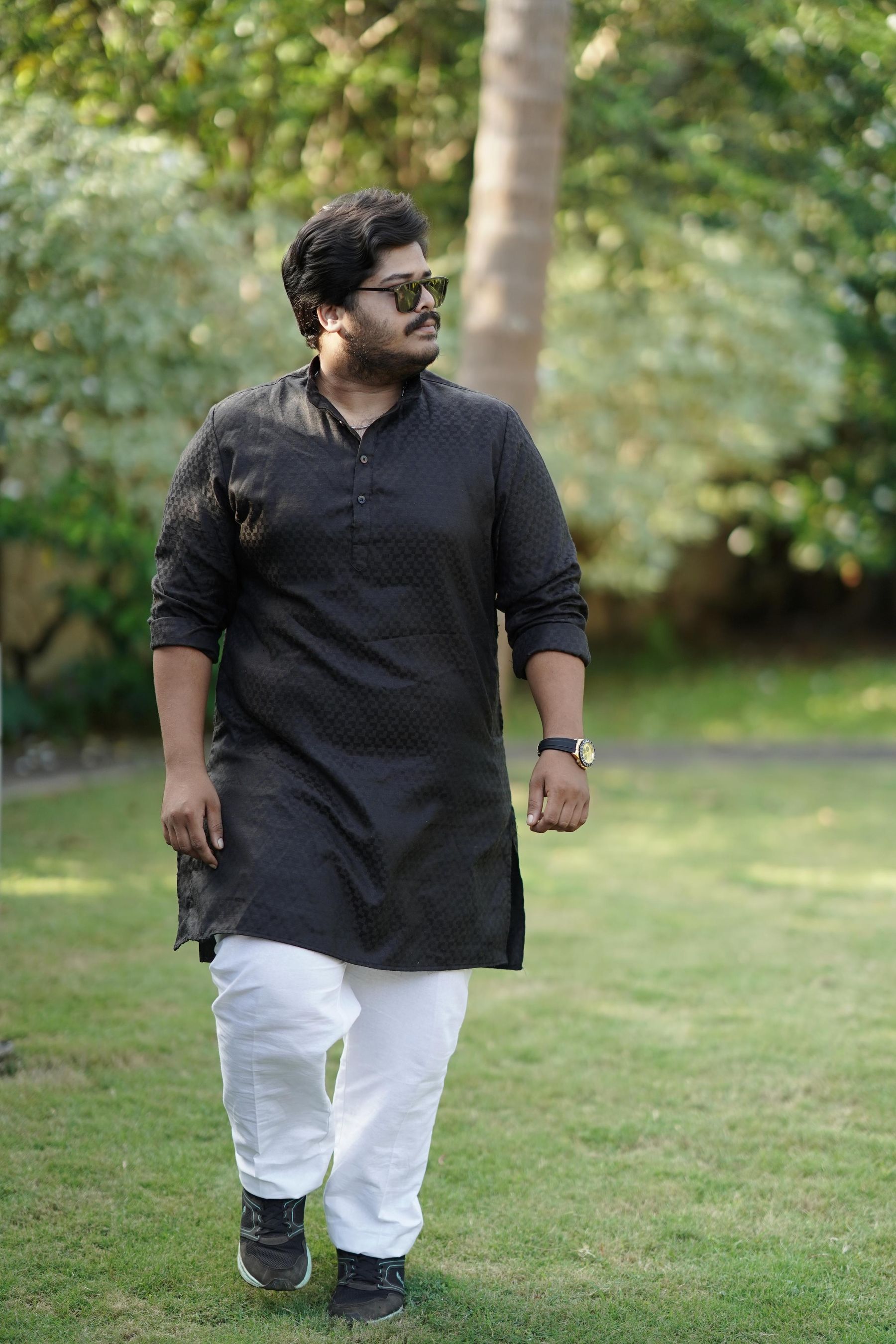 Man in a black kurta walking outdoors